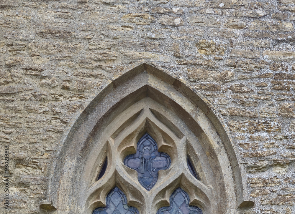 Obraz premium Stonework around the top of a stained glass window in a church. 