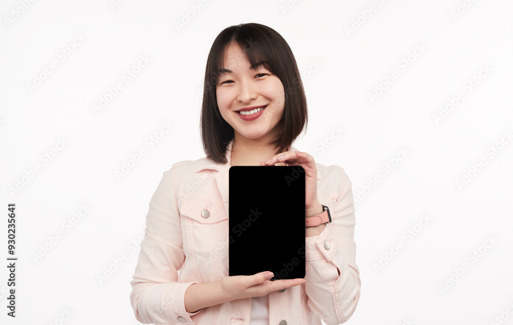 Happy young woman holding a tablet displaying a blank screen. Ideal for tech, mockup, and presentation uses. Happy young woman holding a tablet displaying a blank screen. Ideal for tech, mockup, and presentation uses.