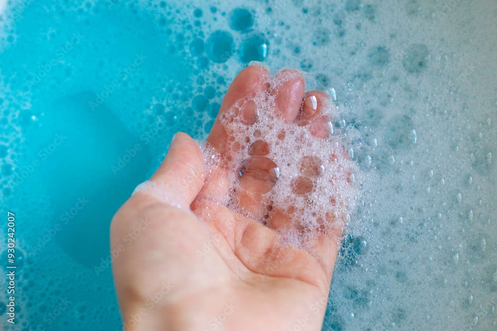 Foam in hand. Blue water with foam bubbles. Foam in hand. Blue water with foam bubbles.