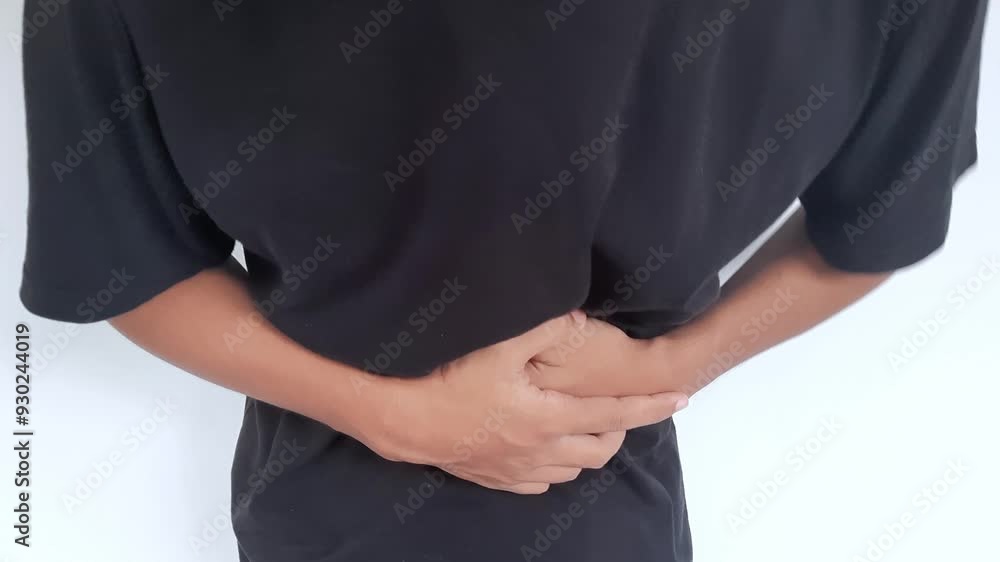 Young man touching his stomach isolated on gray background space. Abdominal pain or ache concept Young man touching his stomach isolated on gray background space. Abdominal pain or ache concept