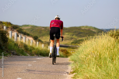 A bicyclist is riding  in the park. Amsterdamse Waterleidingduinen in Duizendmeterweg, Bentveld. Sand-dune nature reserve with a trail network and visitor center. Bentveld, Netherlands. 