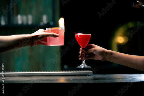 Close up of two people cheering cocktails in bar or disco club drinks and cocktails concept photo