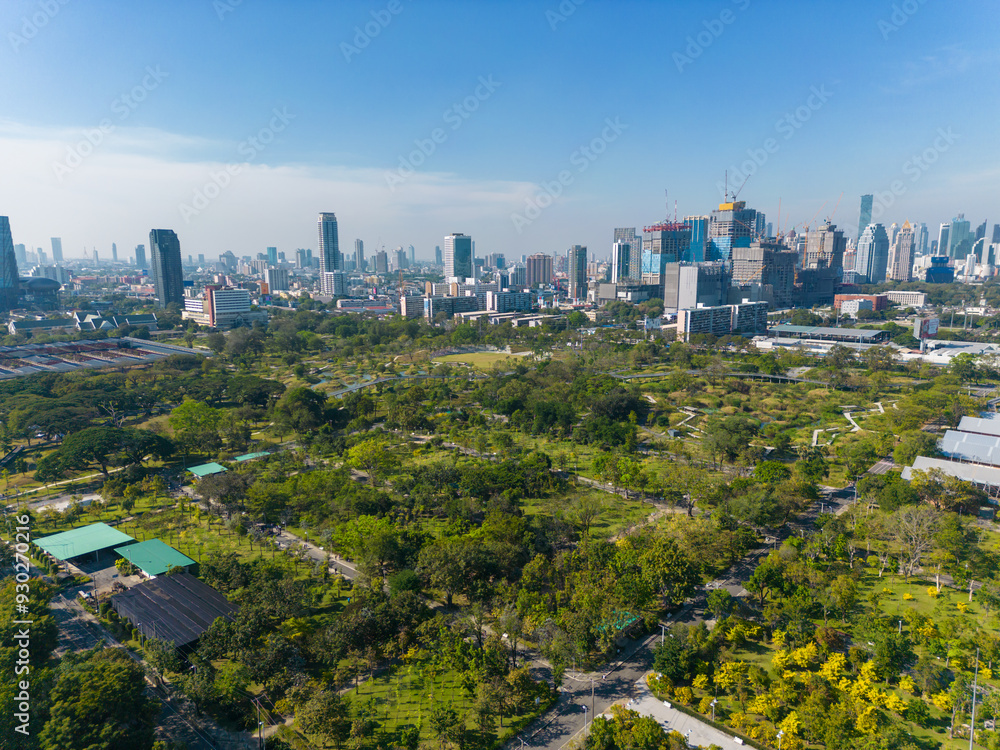 Obraz premium Aerial view modern office building with tropical green tree park in Benchakitti public park downtown