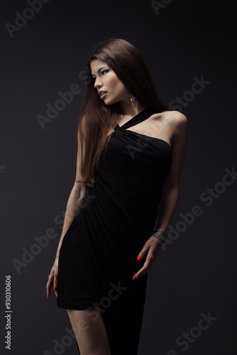 An elegant woman poses in a timeless little black dress against a dark backdrop, embodying grace, and sophistication. Perfect for fashion and style concepts.