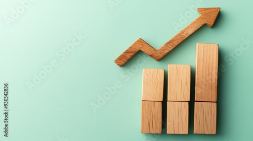 Rising Business Strategy: Wooden Blocks Bar Chart with Upward Arrow on Green Background - Flat Lay Concept