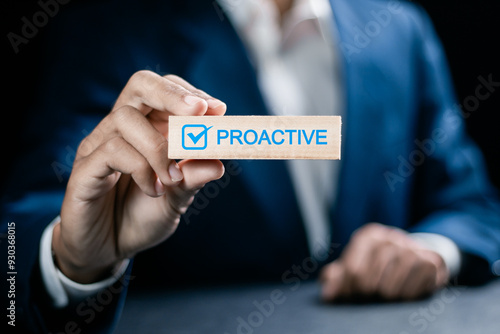 Proactive or reactive solution initiative concept. Businessman hold wooden block with  checkmark and text proactive. photo