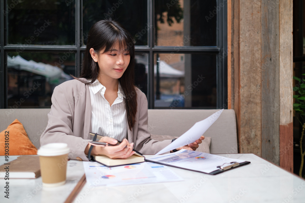 Professional woman sitting at a café, working with documents and a clipboard. Professional woman sitting at a café, working with documents and a clipboard.