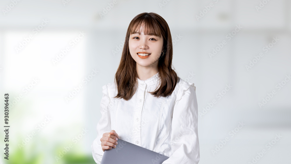 ノートパソコンを持つ若い日本人ビジネスウーマン