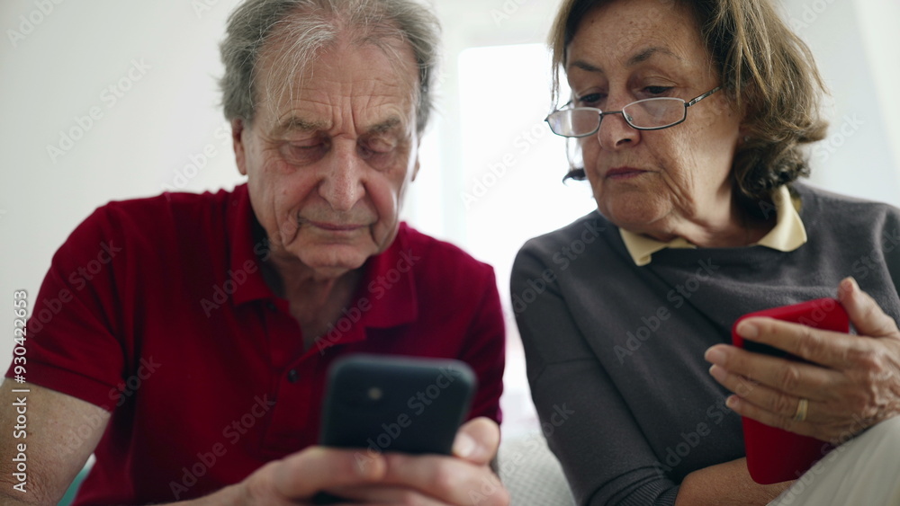 Elderly couple focused on smartphones, exploring apps together, engaged in modern technology, digital literacy, senior lifestyle, bonding over gadgets, casual indoor setting, learning new skills Elderly couple focused on smartphones, exploring apps together, engaged in modern technology, digital literacy, senior lifestyle, bonding over gadgets, casual indoor setting, learning new skills
