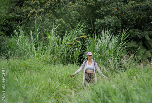 Joven hispana latina sonriendo alegremente y caminando al aire libre con abrigos y gorra. photo