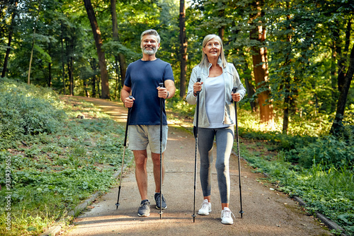Foto Active and Engaged Seniors Delight in a Nature Walk in the Park Using Nordic Pol