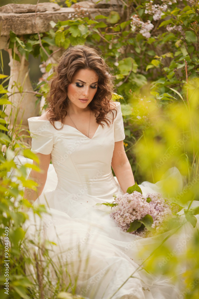 Portrait of beauty bride in white dress. The bride is holding a wedding bouquet of lilacs. Portrait of beauty bride in white dress. The bride is holding a wedding bouquet of lilacs.