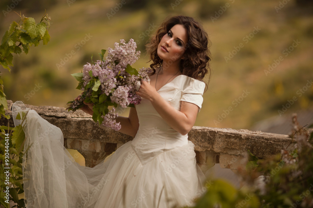 THE EUROPEAN BEAUTIFUL BRIDE WITH THE BEAUTIFUL DARK HAIR WITH THE BOUQUET ON THE BACKGROUND OF THE GREAT BRUSH OF LILAC THE EUROPEAN BEAUTIFUL BRIDE WITH THE BEAUTIFUL DARK HAIR WITH THE BOUQUET ON THE BACKGROUND OF THE GREAT BRUSH OF LILAC