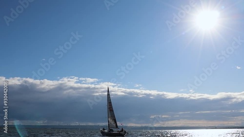 Sunny day on the Volga River as competitors sail gracefully across the shimmering waters, their sails catching the gentle breeze amidst a vibrant celebration of sailing. Copy space
