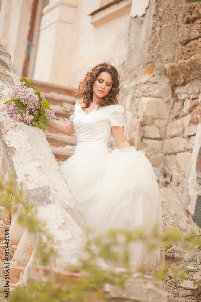 THE EUROPEAN BEAUTIFUL BRIDE WITH THE BEAUTIFUL DARK HAIR WITH THE BOUQUET ON THE BACKGROUND OF THE GREAT BRUSH OF LILAC THE EUROPEAN BEAUTIFUL BRIDE WITH THE BEAUTIFUL DARK HAIR WITH THE BOUQUET ON THE BACKGROUND OF THE GREAT BRUSH OF LILAC