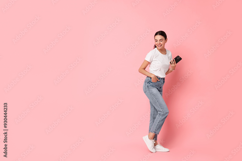 Smiling woman with smartphone on pink background. Space for text Smiling woman with smartphone on pink background. Space for text