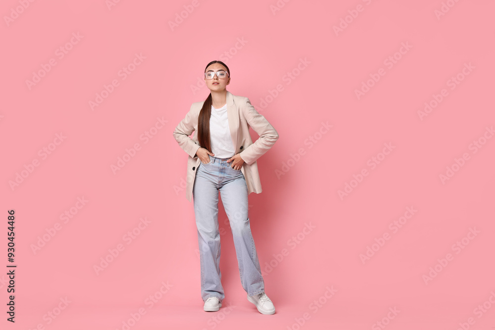 Stylish woman in beige jacket and jeans on pink background Stylish woman in beige jacket and jeans on pink background