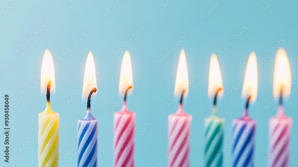 Row of colorful striped birthday candles burning Row of colorful striped birthday candles burning