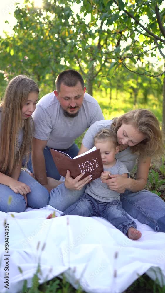 a family reading the holy bible on a picnic in the garden a family reading the holy bible on a picnic in the garden