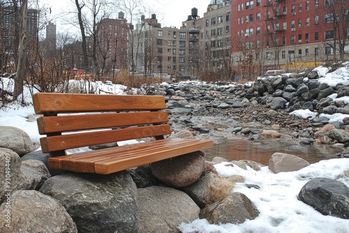 Wooden Bench Resting on Rocks by a Snowy Stream photo