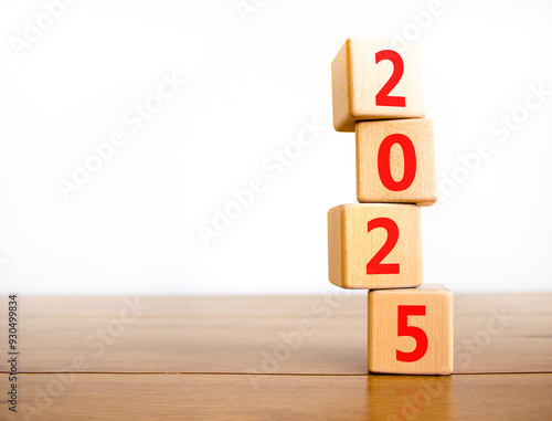 Business concept of 2025 new year symbol. Beautiful turned wooden cube and changed number 2024 to 2025. Beautiful wooden table white background, copy space. Business 2025 happy new year concept.