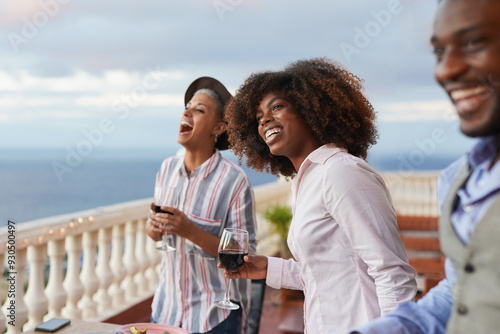 Bild auf Leinwand Multiracial people drinking red wine during vegetarian dinner at house terrace -