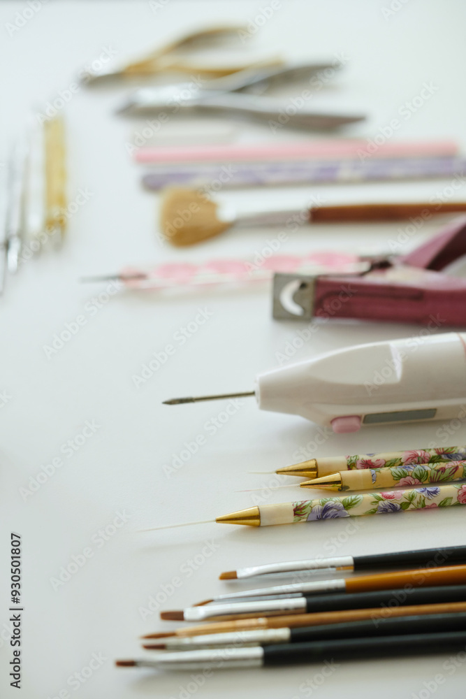 Fototapeta premium Various artistic tools, such as paintbrushes and decorative pens, displayed neatly on white background These tools may be used for painting, drawing, and other creative activities
