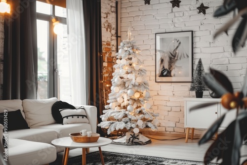 A modern, minimalist living room with a simple, white Christmas tree adorned with monochrome decorations
