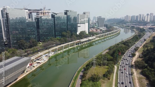 Visão aérea de prédios comerciais a beira do rio tietê com o fluxo de veículos no trânsito da marginal pinheiros na cidade de são paulo, sp, brasil captada por um drone em 2024 photo