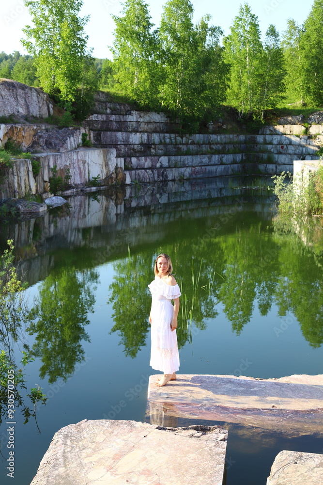 Fototapeta premium Beautiful girl in white dress enjoys summer day in nature 