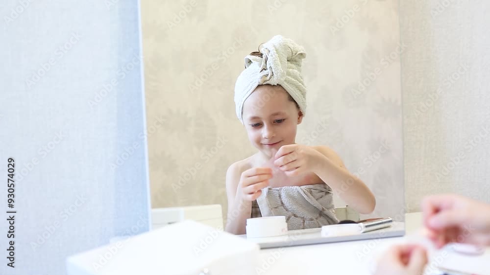 A young girl wrapped in a towel, sitting at a vanity with various skincare products, looking at her reflection in the mirror. The image captures a moment of self-care and relaxation. A young girl wrapped in a towel, sitting at a vanity with various skincare products, looking at her reflection in the mirror. The image captures a moment of self-care and relaxation.
