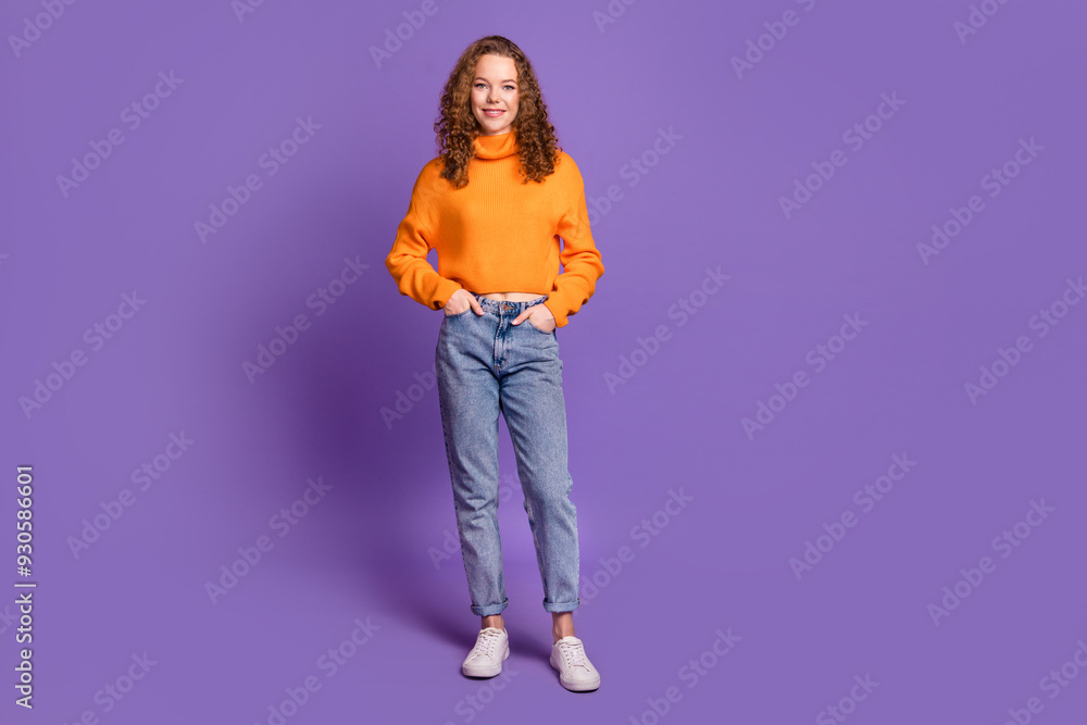 Photo of lovely young girl posing empty space wear orange pullover isolated on violet color background Photo of lovely young girl posing empty space wear orange pullover isolated on violet color background