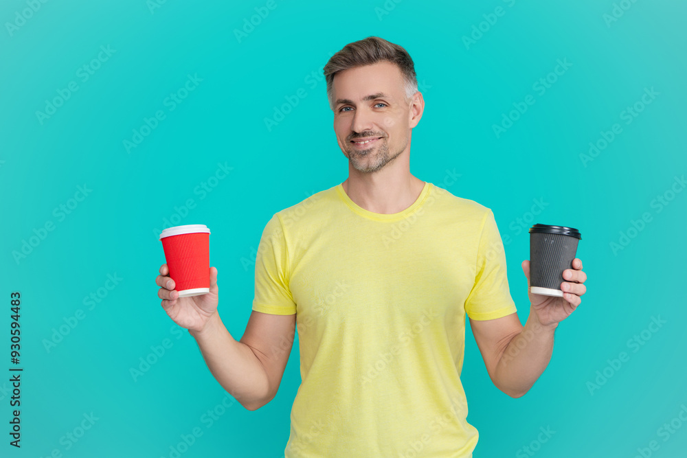 Mature man with paper cup of coffee or tea drinking decaf in morning isolated on blue Mature man with paper cup of coffee or tea drinking decaf in morning isolated on blue