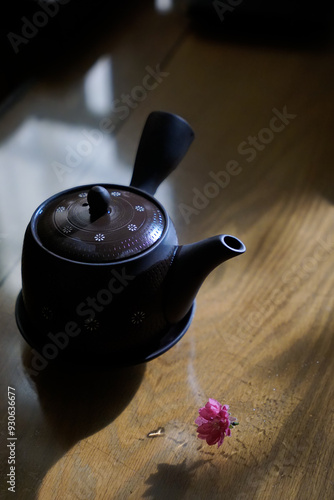 Traditional Japanese style ceramic tea pot with a pink cherry blossom on the side photo