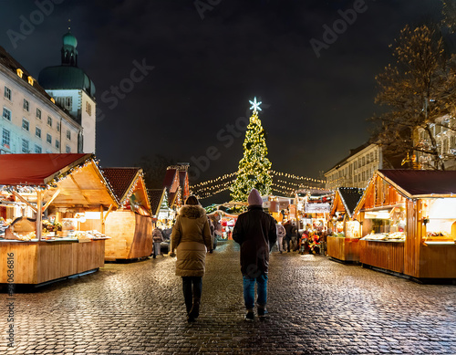 Promenade en couple au marché de Noël pendant la soirée sous les guirlandes photo