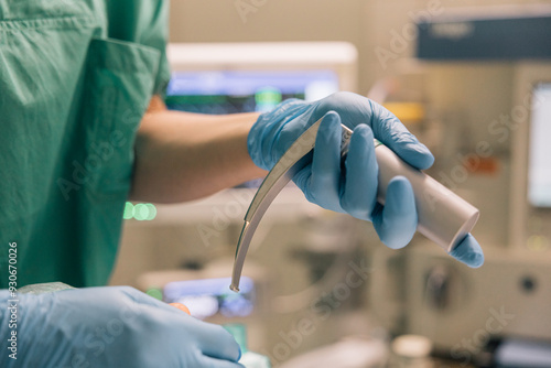 Close up of a medical professional’s gloved hands holding a tool to perform an endotracheal intubation