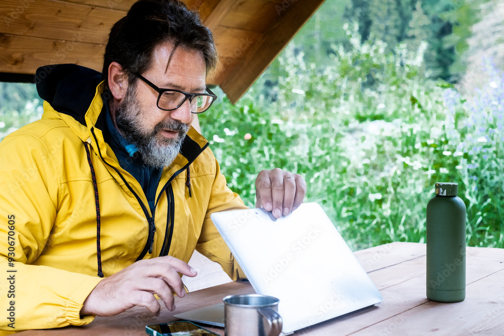 Mature freelance opening laptop ready to work in outdoors alternative nature office workplace. Traveler lifestyle. Remote worker everywhere with roaming 5g connection data. Adventure lifestyle people Mature freelance opening laptop ready to work in outdoors alternative nature office workplace. Traveler lifestyle. Remote worker everywhere with roaming 5g connection data. Adventure lifestyle people
