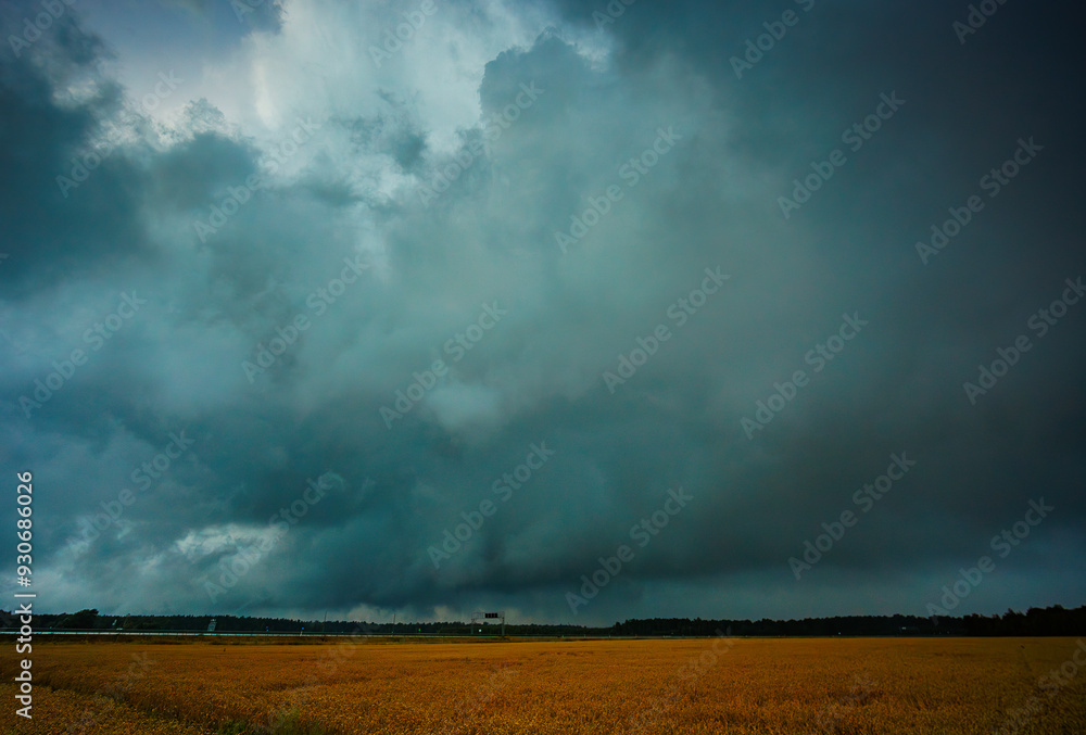 Tornadic storm clouds over the field, creating threatening atmosphere in countryside Tornadic storm clouds over the field, creating threatening atmosphere in countryside