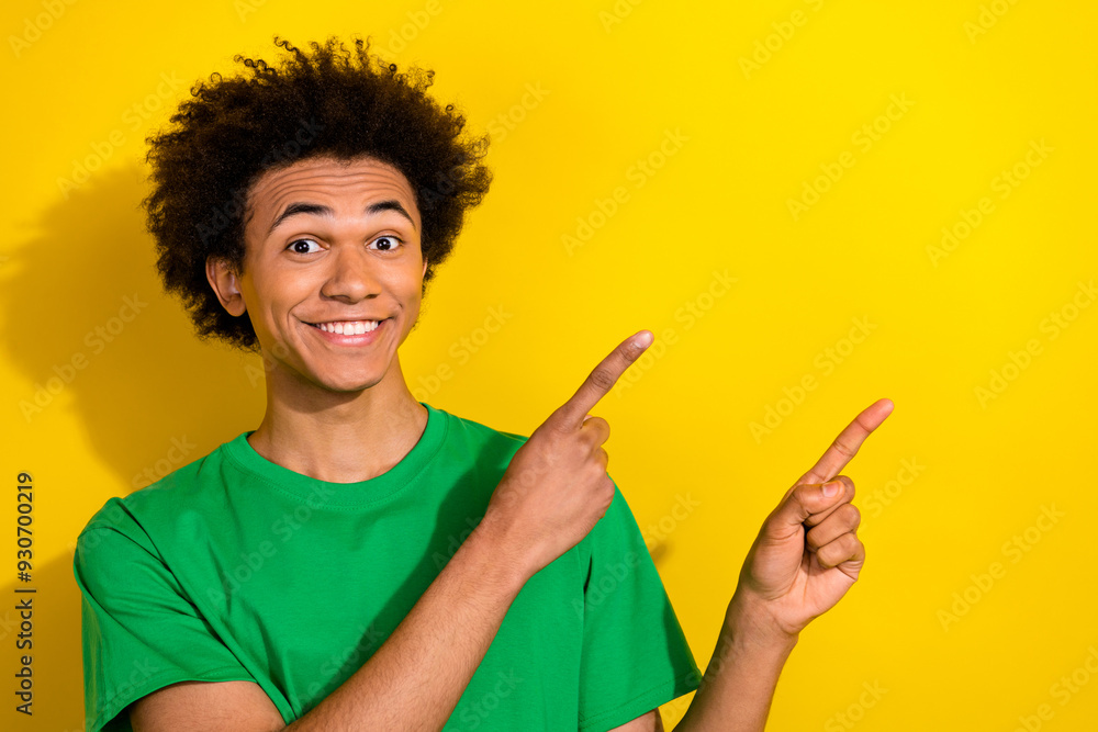 Photo of handsome good mood guy wear green t-shirt showing two fingers emtpy space isolated yellow color background