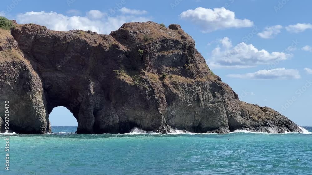 Grotto in the middle of a sea cliff, around the turquoise sea and waves Grotto in the middle of a sea cliff, around the turquoise sea and waves