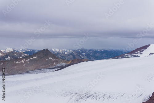 view of the high mountains above the clouds from the glacier on the slope of Mount Elbrus photo