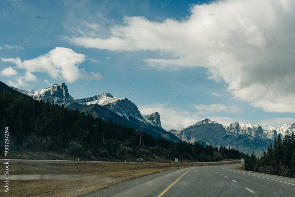 Naklejka premium Scenic road through the Canadian Rockies, surrounded with rocky mountains. Taken in Banff National Park, Alberta, Canada