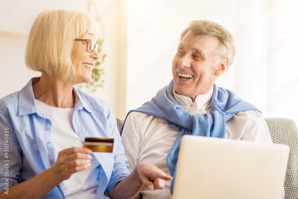 Modern mature couple shopping online on laptop, using credit card when choosing new clothes Modern mature couple shopping online on laptop, using credit card when choosing new clothes