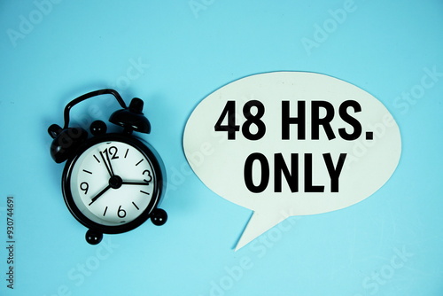 48 Hrs only text on speech bluble with alarm clock top view on blue background photo