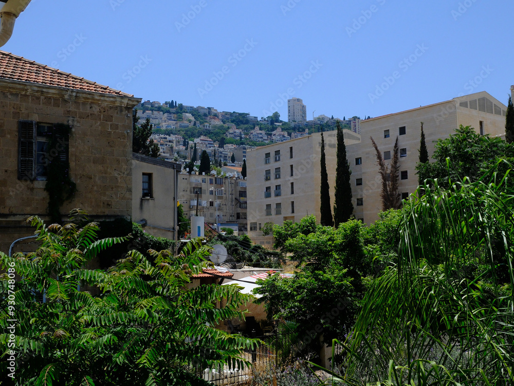 Verdant cityscape of Haifa, Israel showcasing ancient and modern buildings under a clear blue sky, nestled on a lush hillside. Verdant cityscape of Haifa, Israel showcasing ancient and modern buildings under a clear blue sky, nestled on a lush hillside.