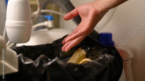Assorted unlabeled batteries are thrown into the household waste bin under the kitchen sink