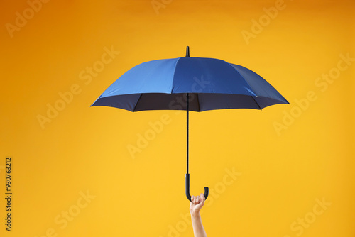 Woman with blue umbrella on yellow background, closeup