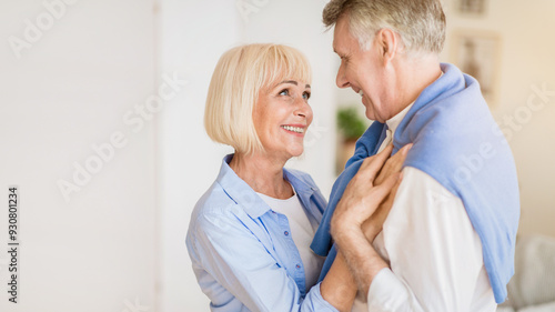 Happy senior couple embracing, enjoying time at home and looking at each other