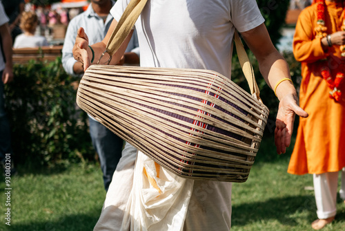 A man plays traditional Indian drums at a street festival. Close-up, no face.