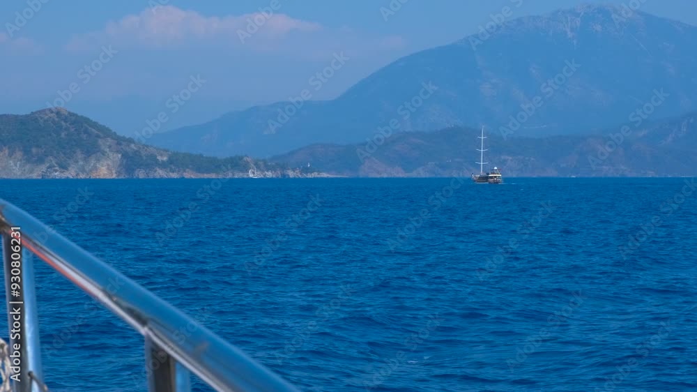 Boat in frothy sea by mountains. A luxury boat floating against the blue island in the ocean during voyage time. Boat in frothy sea by mountains. A luxury boat floating against the blue island in the ocean during voyage time.